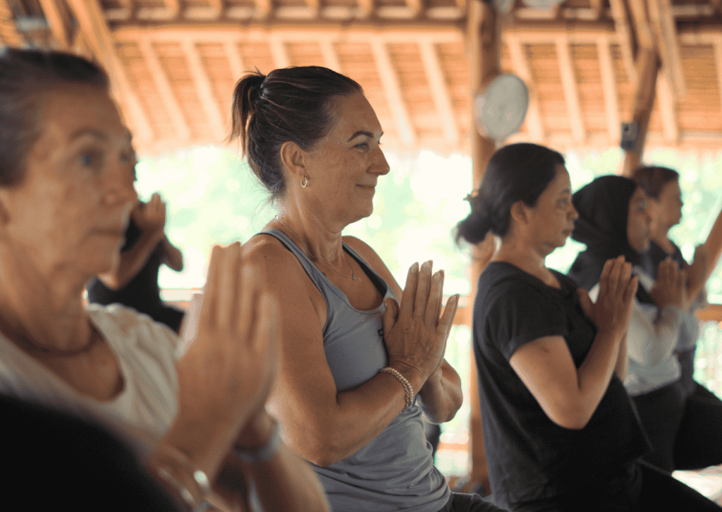 Bali’s Best 7-Day Retreat: Yoga, Wellness & the Art of Slowing Down 10 Diverse group of women practicing yoga with hands in prayer pose at Power of Now Oasis